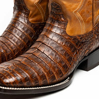 Top angled view highlighting hand-polished finish and caiman skin texture on Tucson boot.