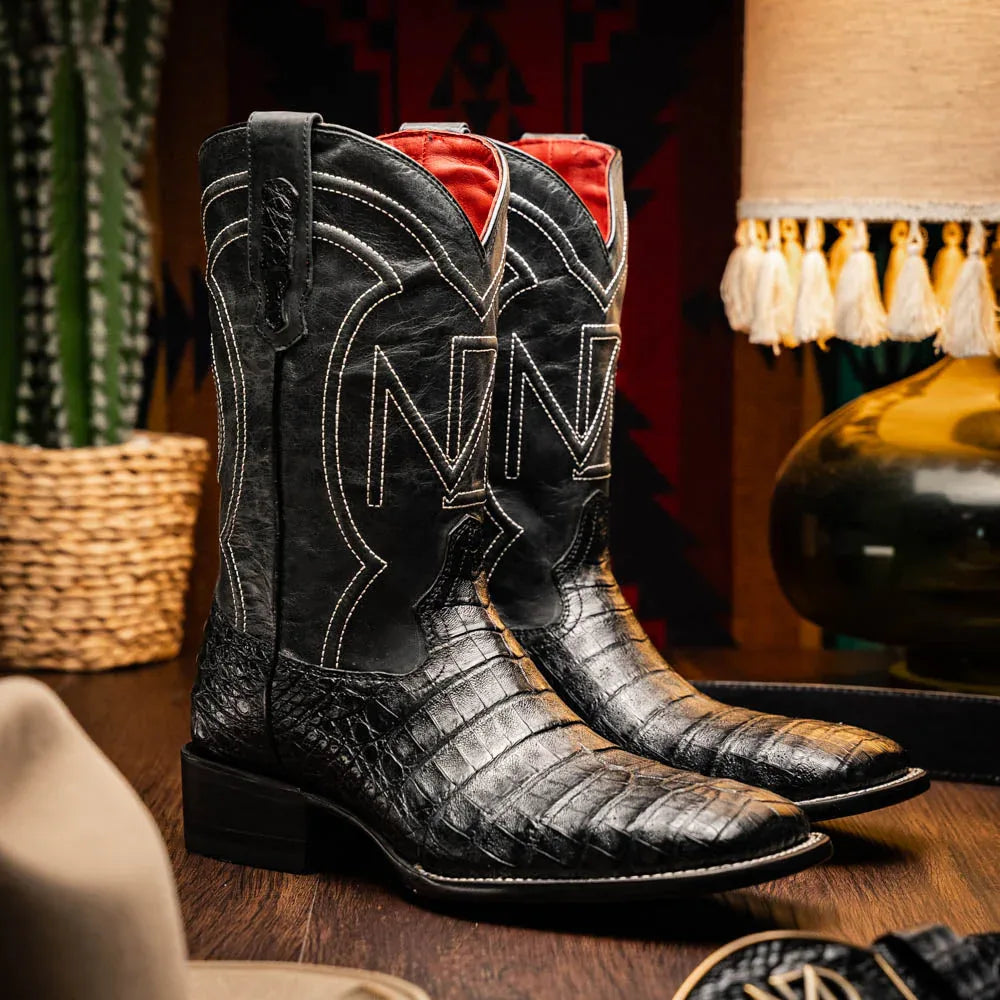 Lifestyle image of a man wearing Tucson Black cowboy boots with jeans in an outdoor setting.