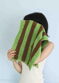 Soft combed cotton towel with bright, playful stripes draped over a chair.