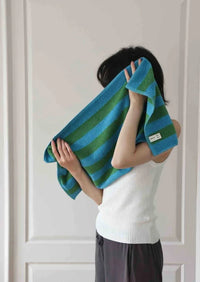 Bath towel featuring eye-catching retro stripes laid out, showing texture and color.