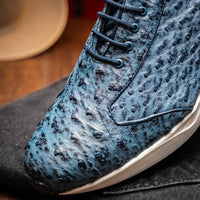 Lifestyle photo of navy blue ostrich skin sneakers in urban setting with focus on premium craftsmanship.