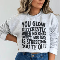 Sport grey sweatshirt featuring the phrase 'You Glow Differently When No Ones Dusty A-s Son Is' in peach-colored lettering.